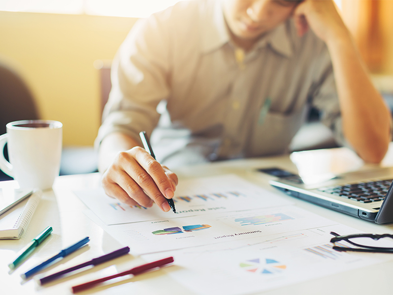 Photo of a person reviewing charts and data