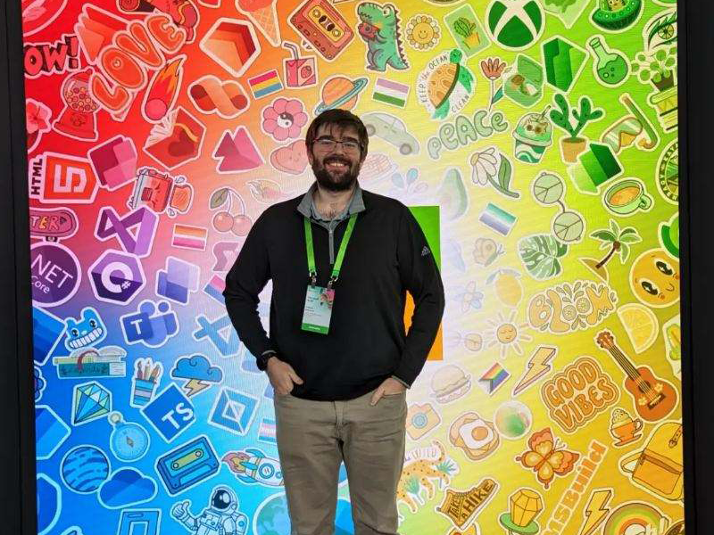 Photo of Trevor Rietcheck in front of a banner with Microsoft logos