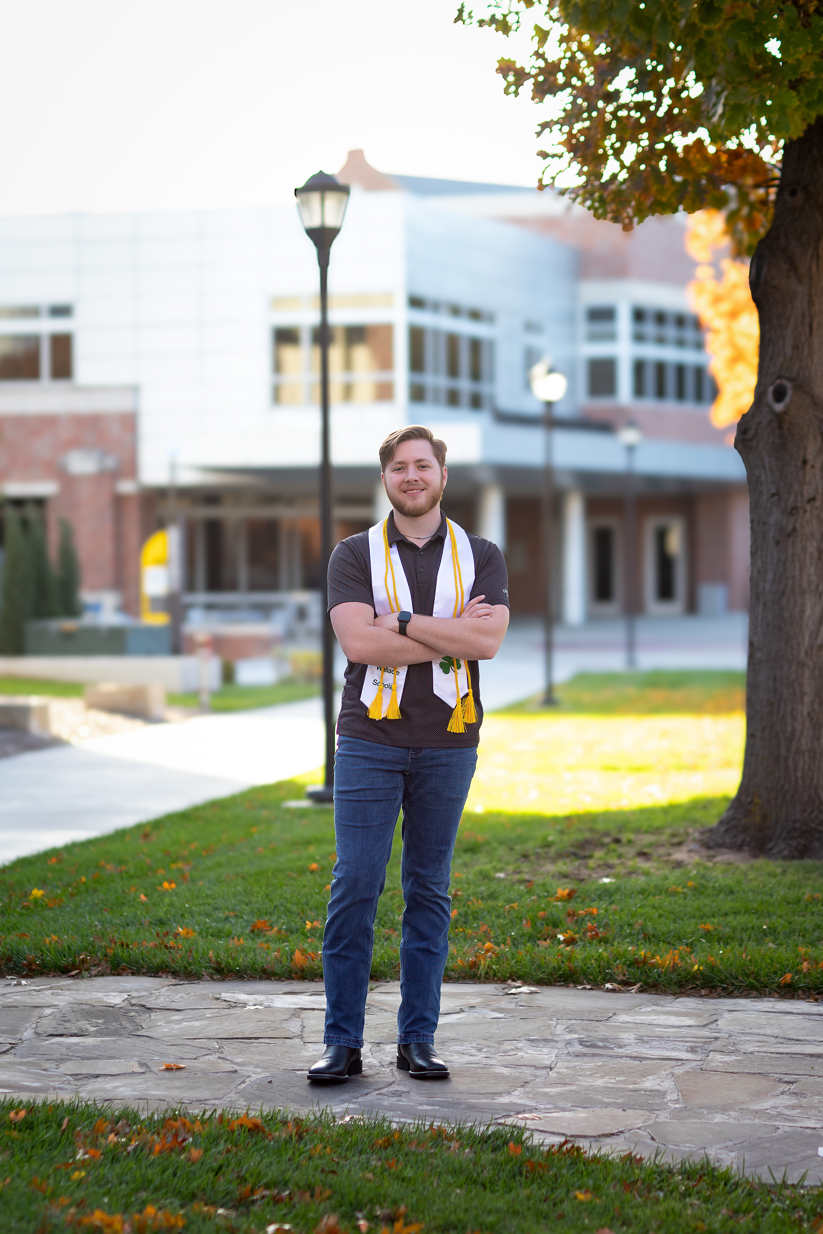 Photo of Alex Harms wearing their graduation stole.