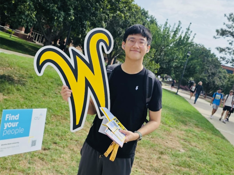 Photo of Binh Lam holding a Wichita State 'W' sign.