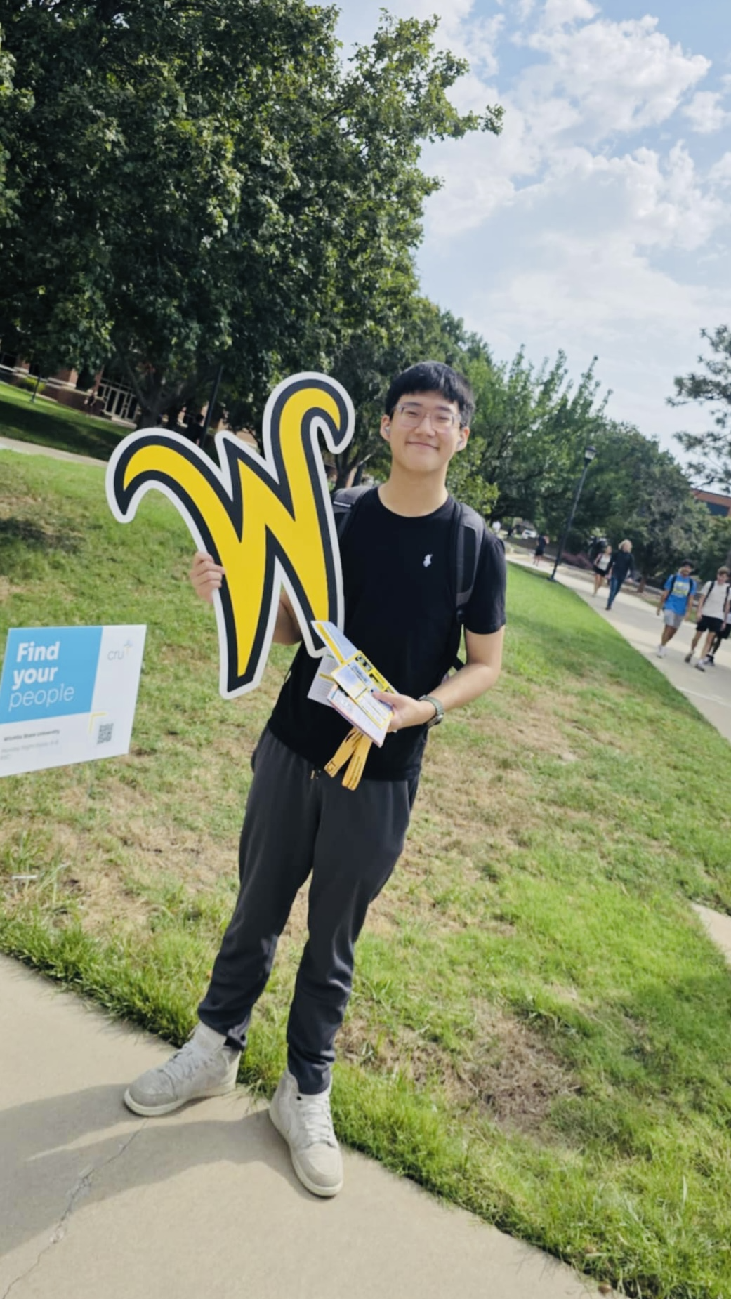 Photo of Binh Lam holding a Wichita State 'W' sign.