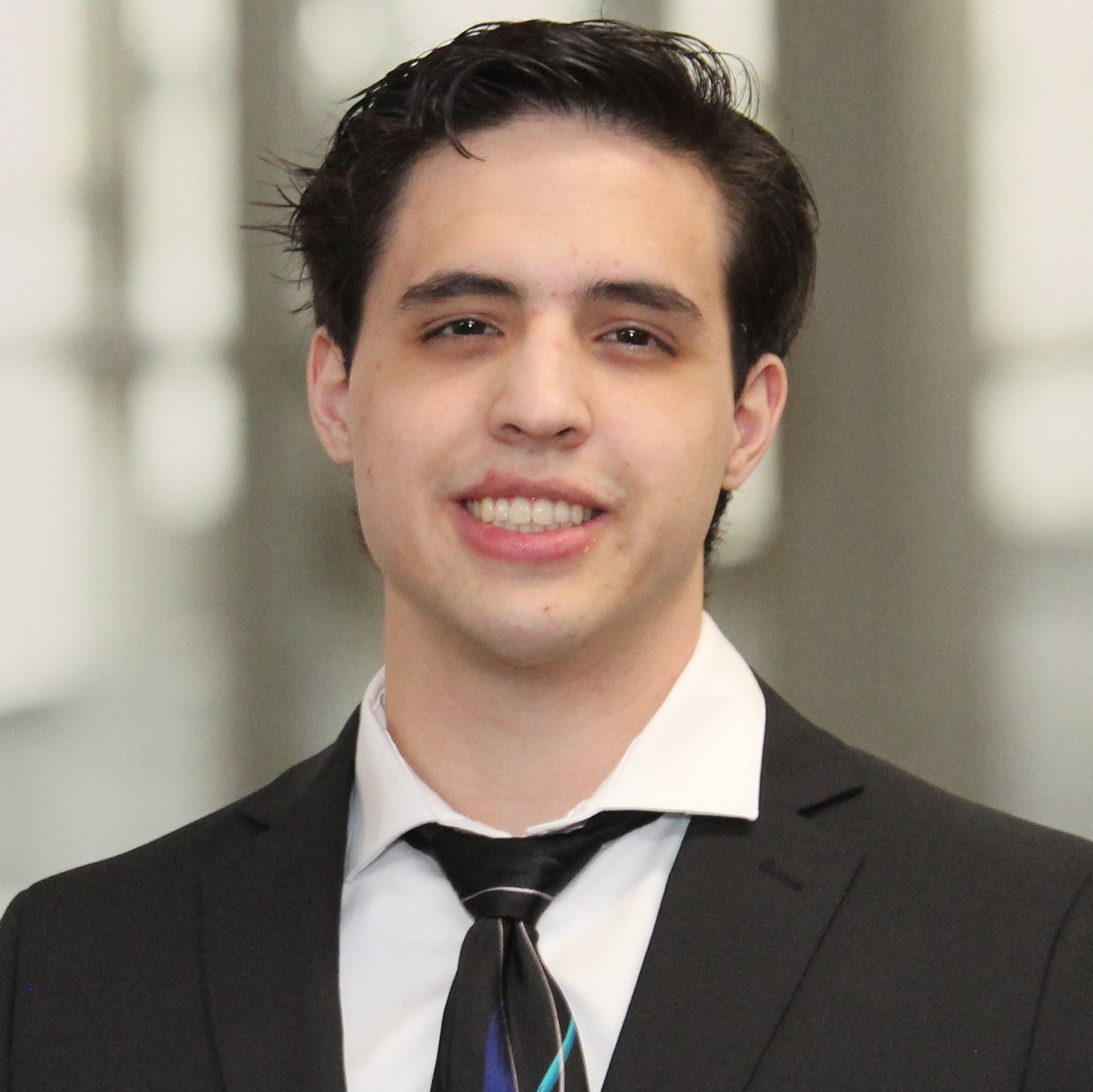 Photo of Justen Lee in a suit and tie.