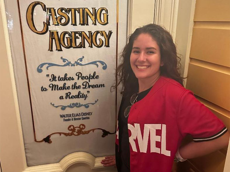 Photo of Tiahna Padilla in front of Disney World casting agency sign