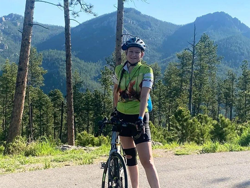Photo of Grace Standfast cycling in the mountains