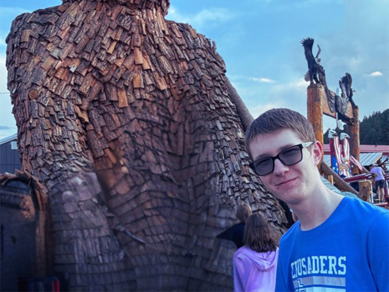 Photo of Connor Beard in front of a bear statue