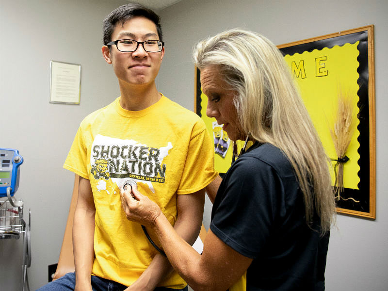 Nurse giving student a shot