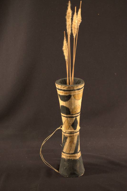 A wooden quiver decorated with stripes, diamonds, and half circle designs, holding four darts.