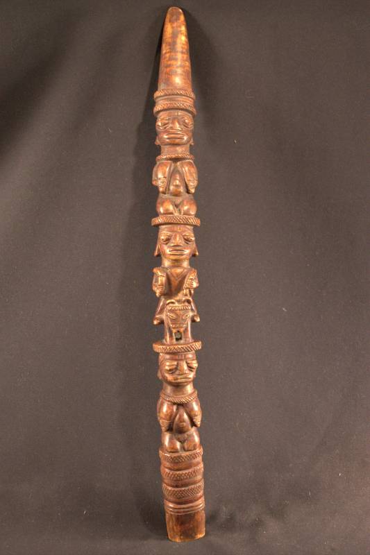 Curved horn colored dark brown with three figures. On top and bottom are identical kneeling female figures holding their breasts. Middle figure is riding a horse and holding whips or fly whisks in each hand. In-between figures are bands of crisscross patterns.