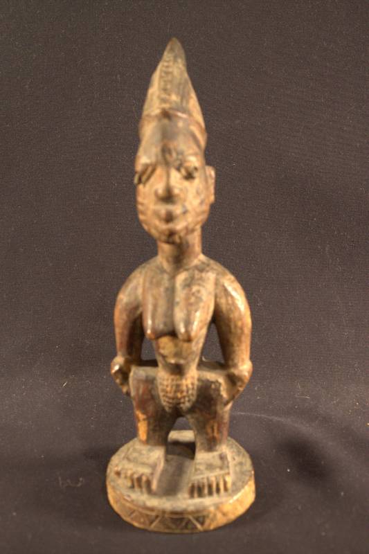 Wooden figure of a female standing with hands on hips.
