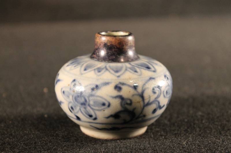 Small bulbous-shaped jar with flourish floral designs. Unglazed neck with small neck.