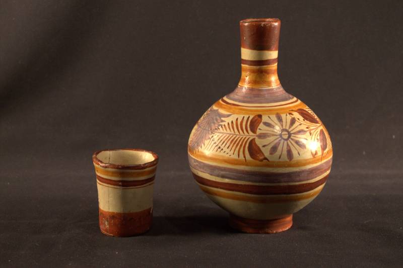 Water jar and cup are sitting side by side