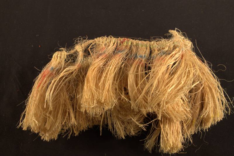 Arm band made of plant fibers with faded colors along the top portion.