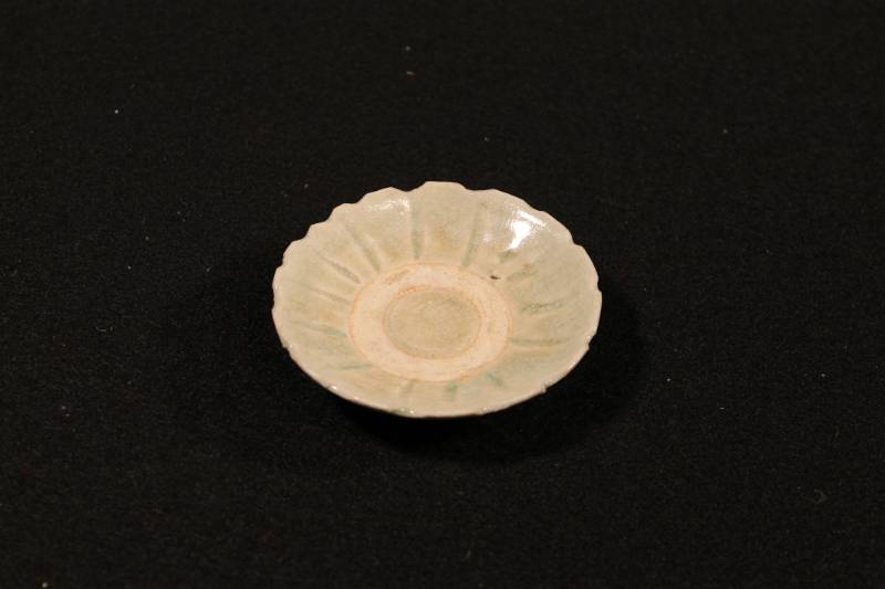 Small saucer plate in the shape of a chrysanthemum and glazed with an Annamese pale green celadon.