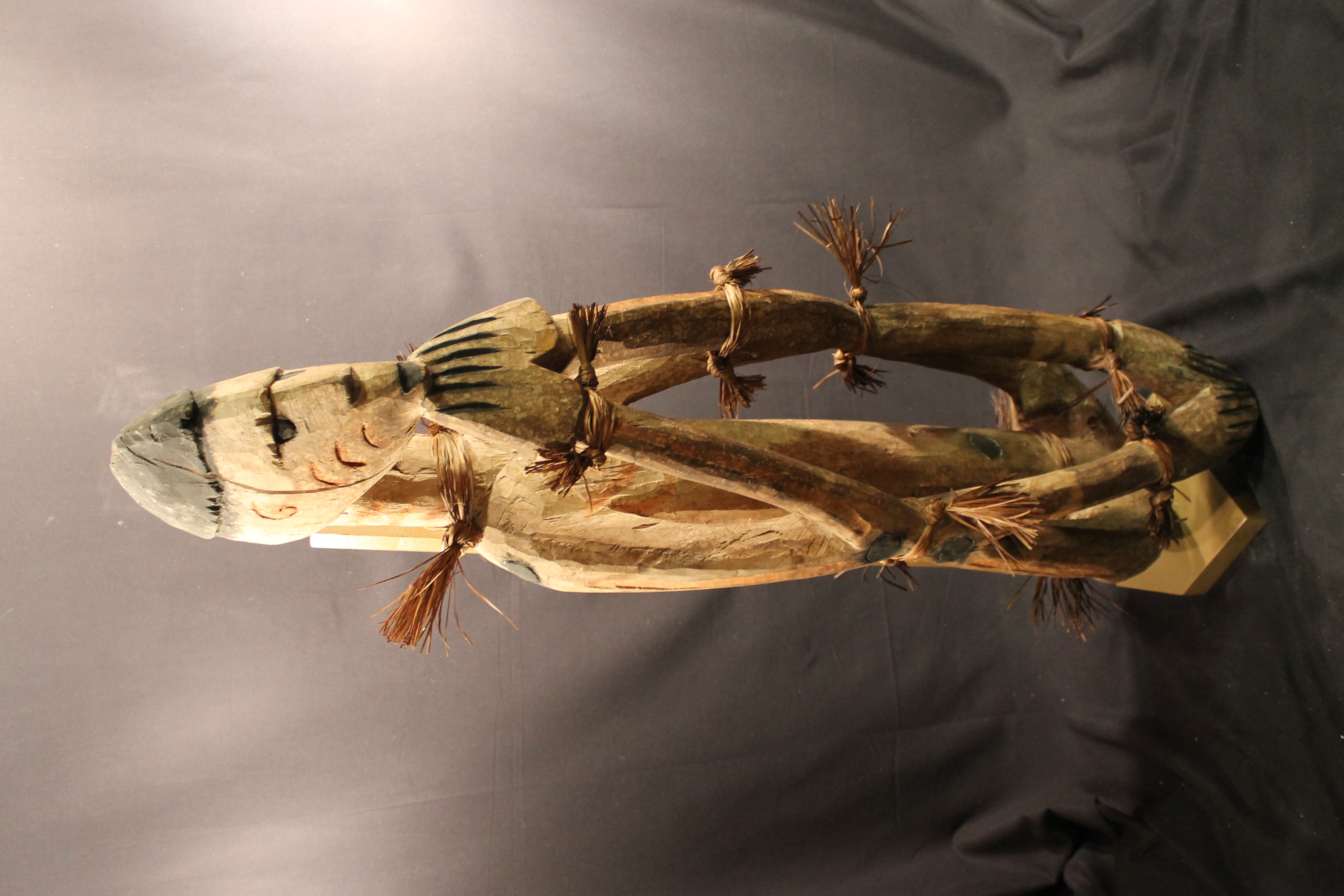  Carved wooden female figure crouched with elbows resting on knees