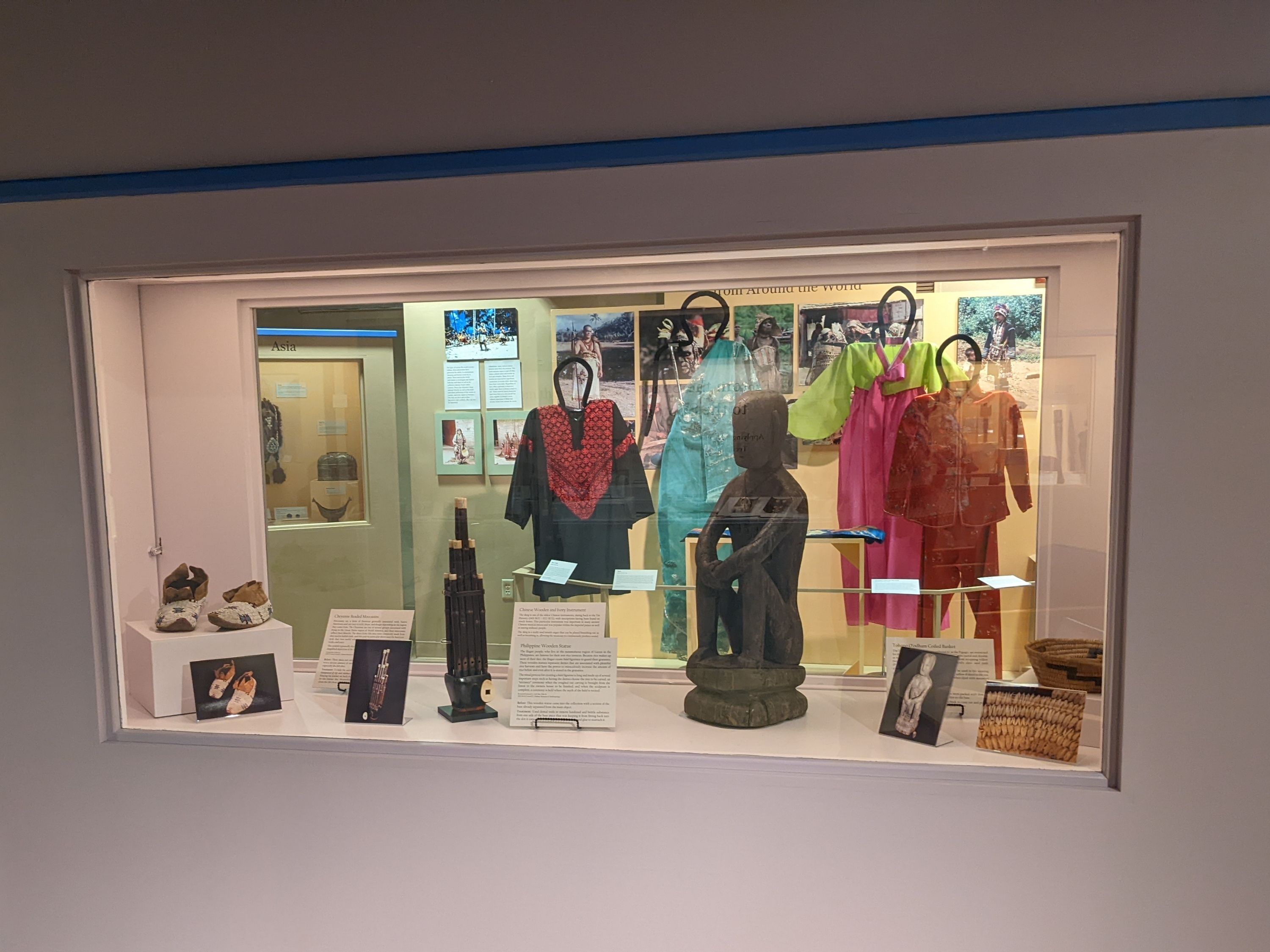 The case features glass on both sides of the case. The case holds four objects with the labels and before-treatment photographs in front of the objects.
