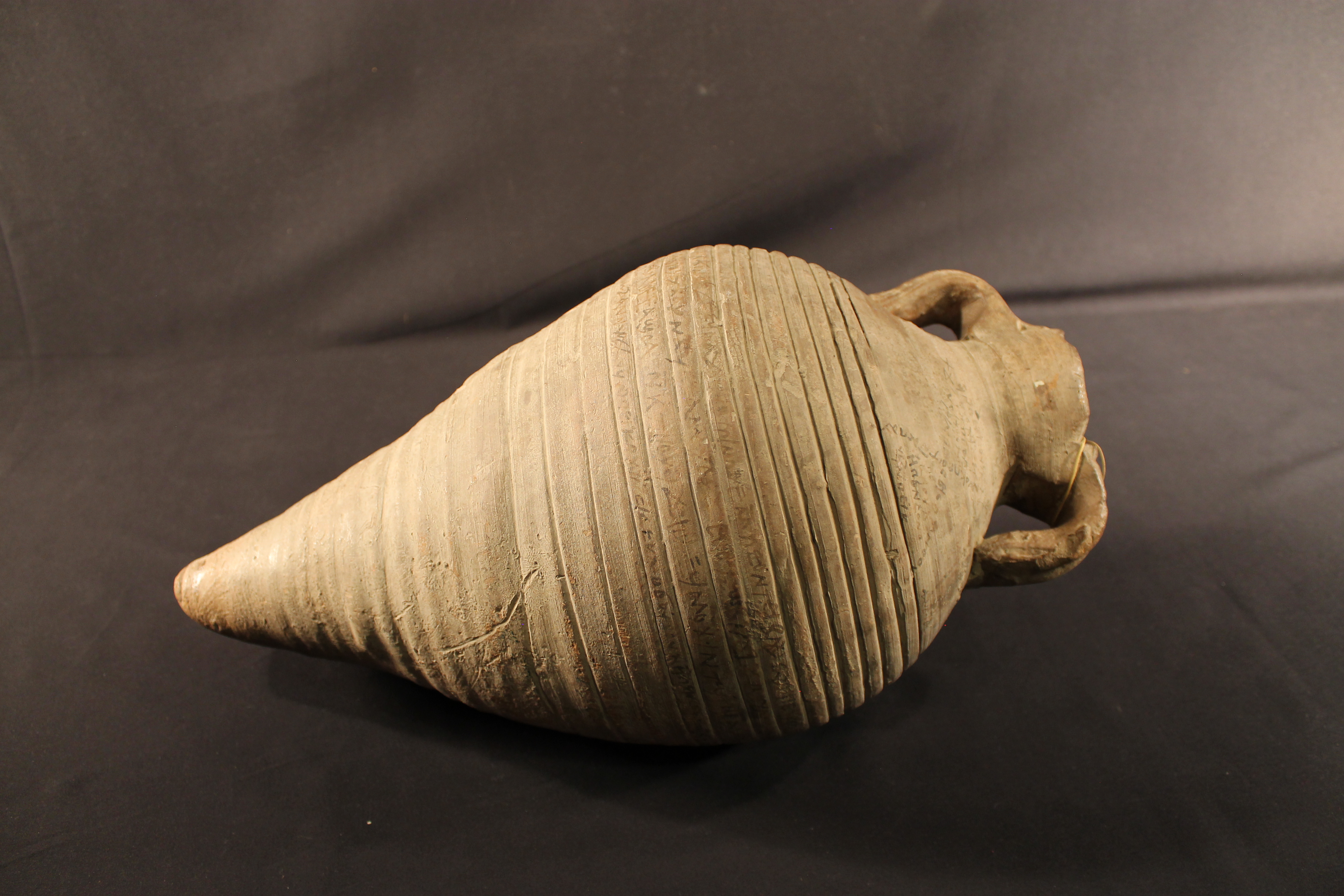 Ceramic water jug with white faded inscription.