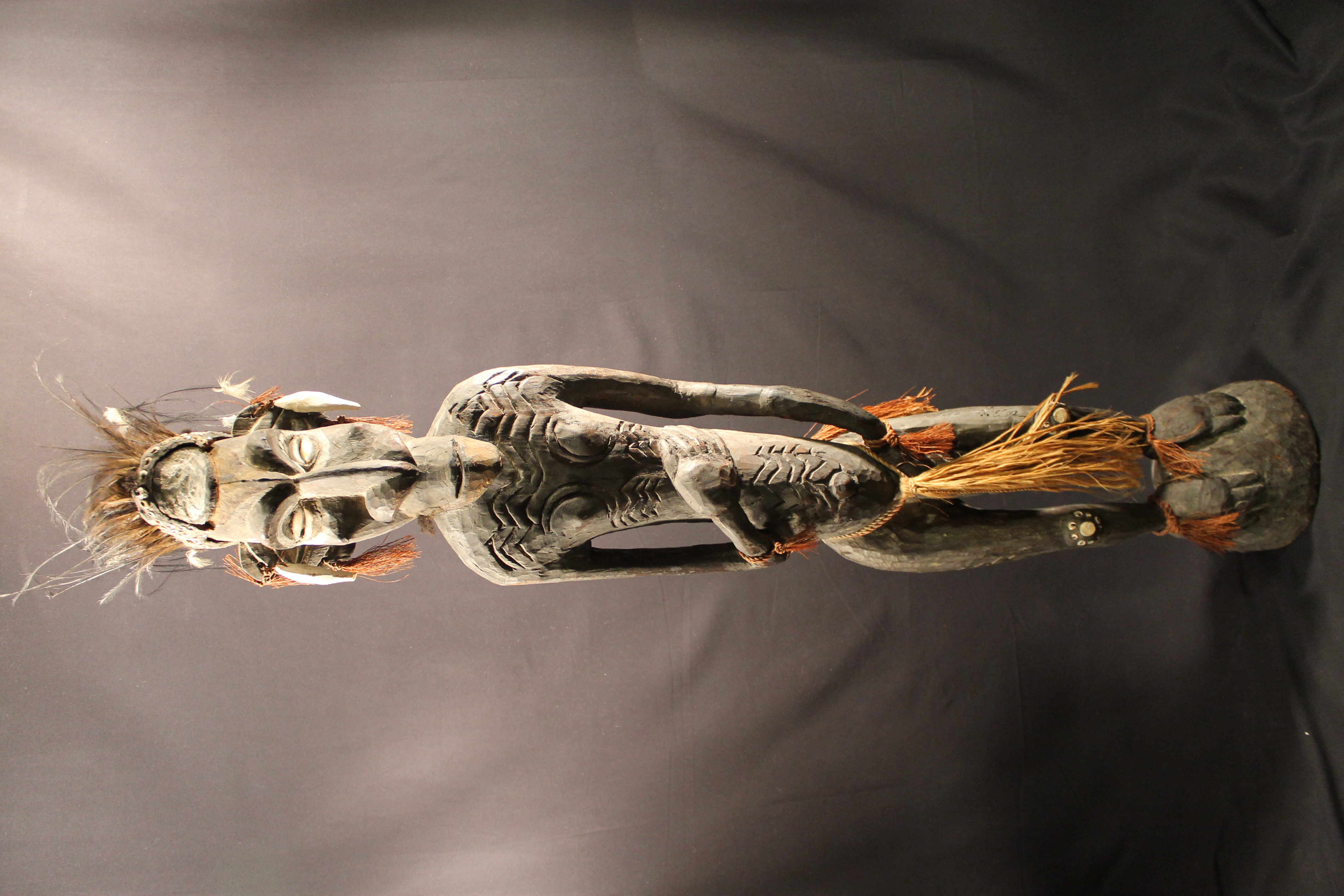  Figure of a man wearing a headdress of feathers and is wearing a grass tassel loincloth.