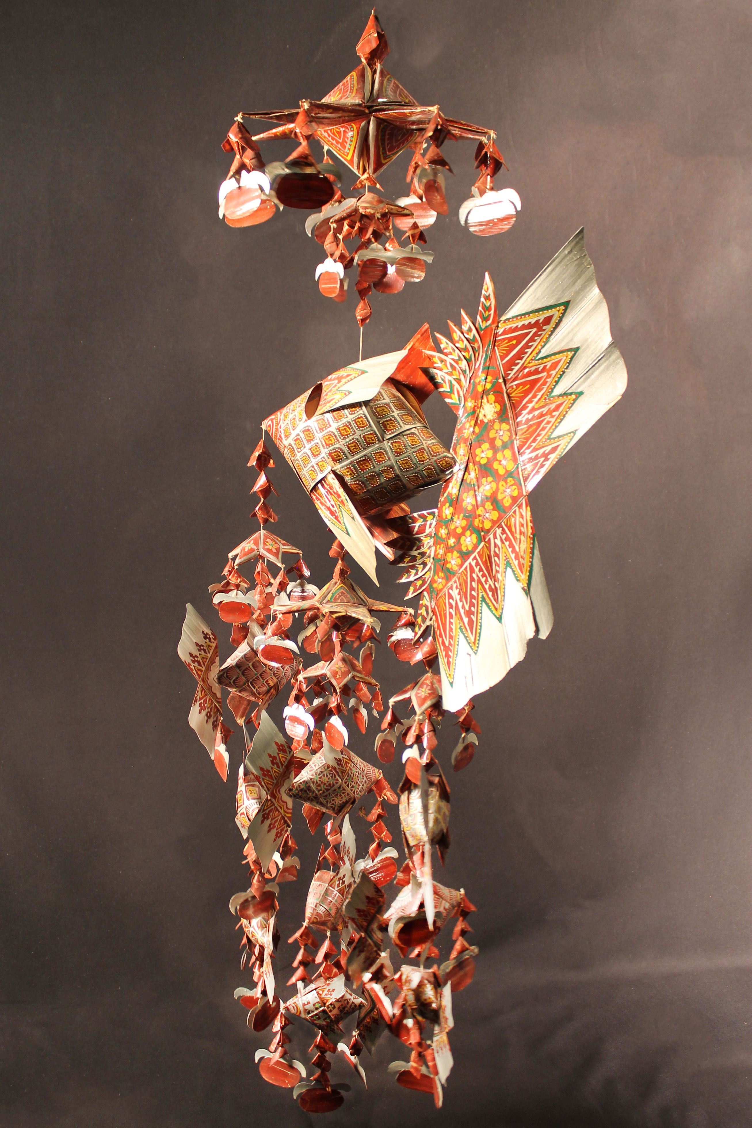 Mobile features large red fish and has three attached strands of stars and fish. 