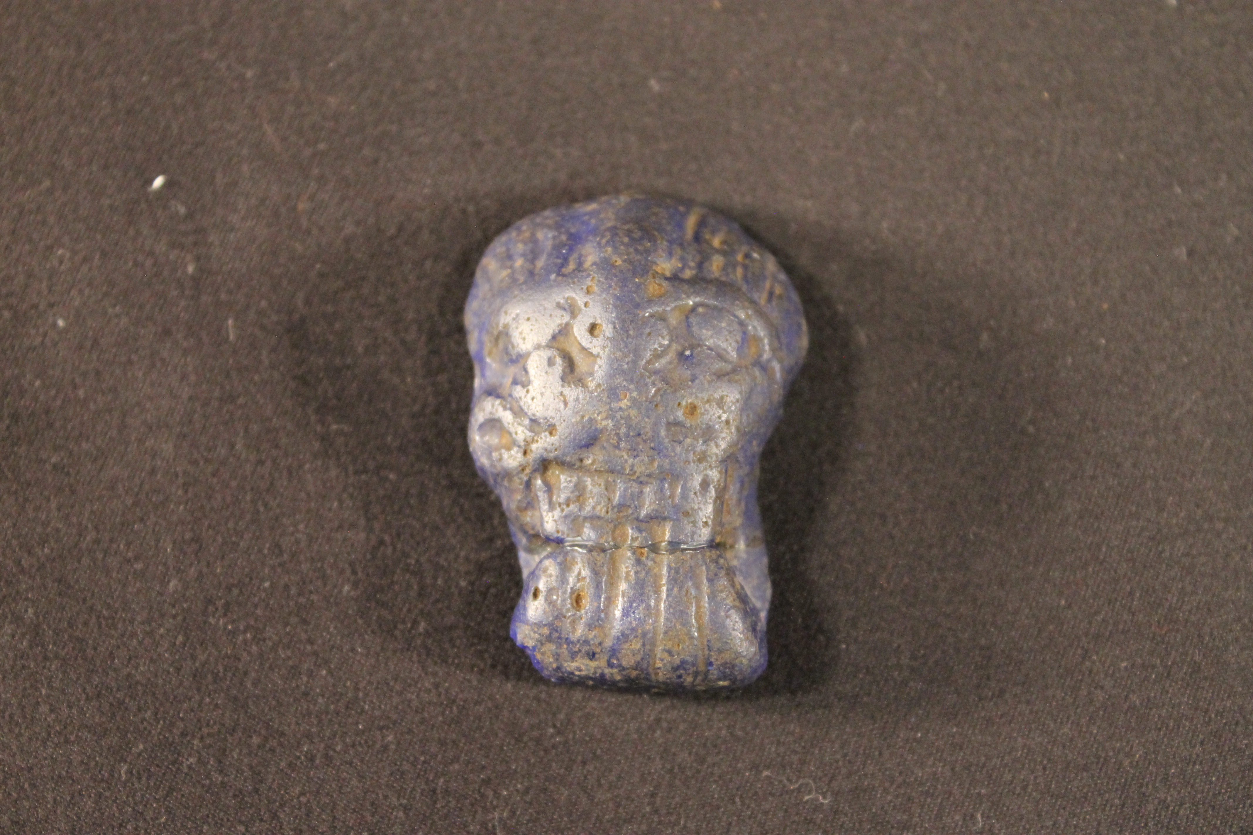 Black stonss carved into the shape of a human male face.