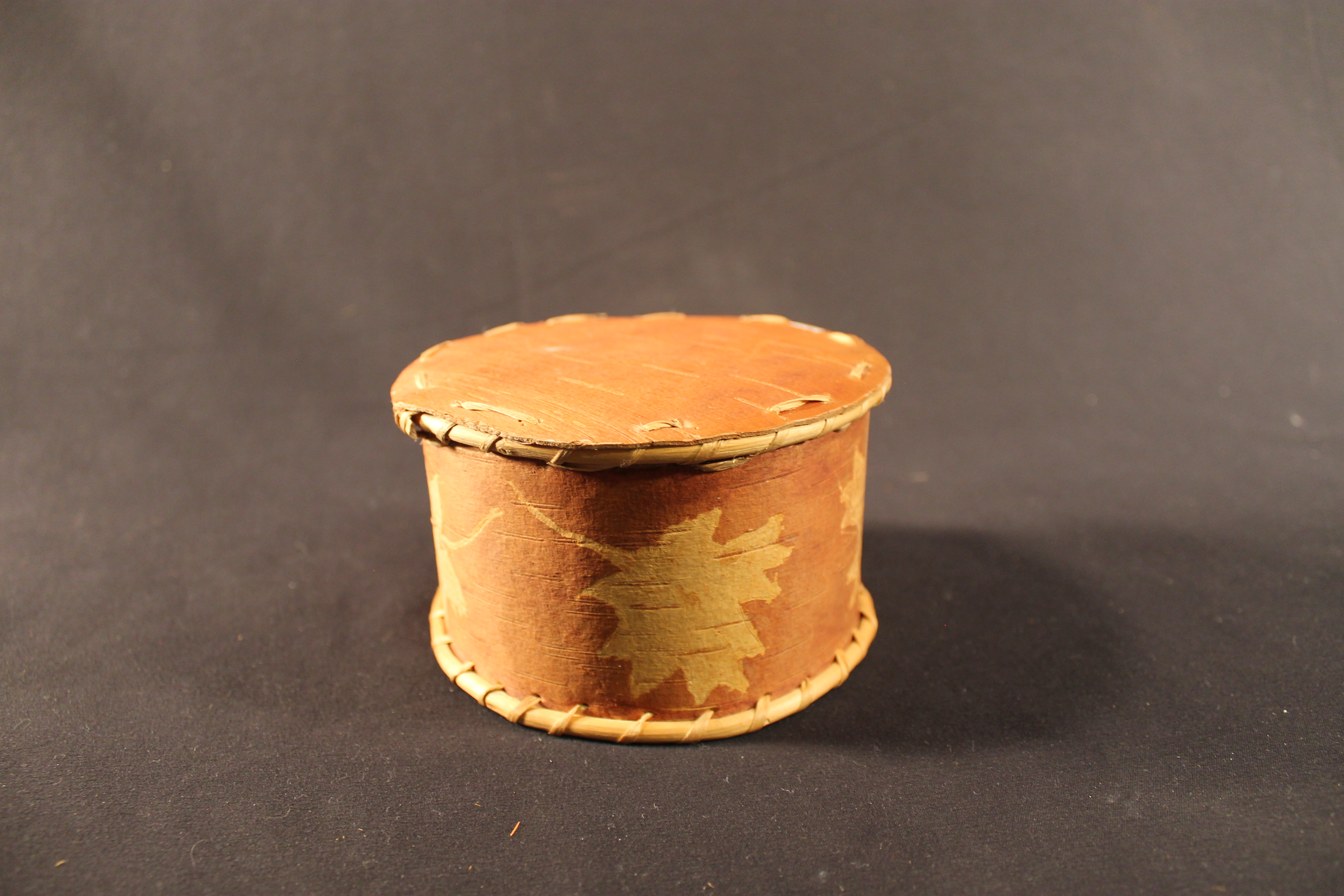 Beige and brown basket with leaf pattern.