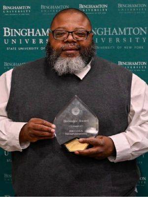 Phillip Samuels holding Brownlee Award