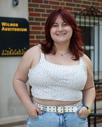 Alexandra Enmark stands outside of Wilner Auditorium where she works as a student intern in the School of Performing Arts.
