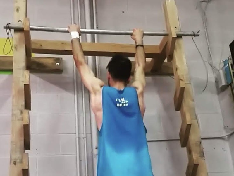 Max Atefi hanging on to high metal bar