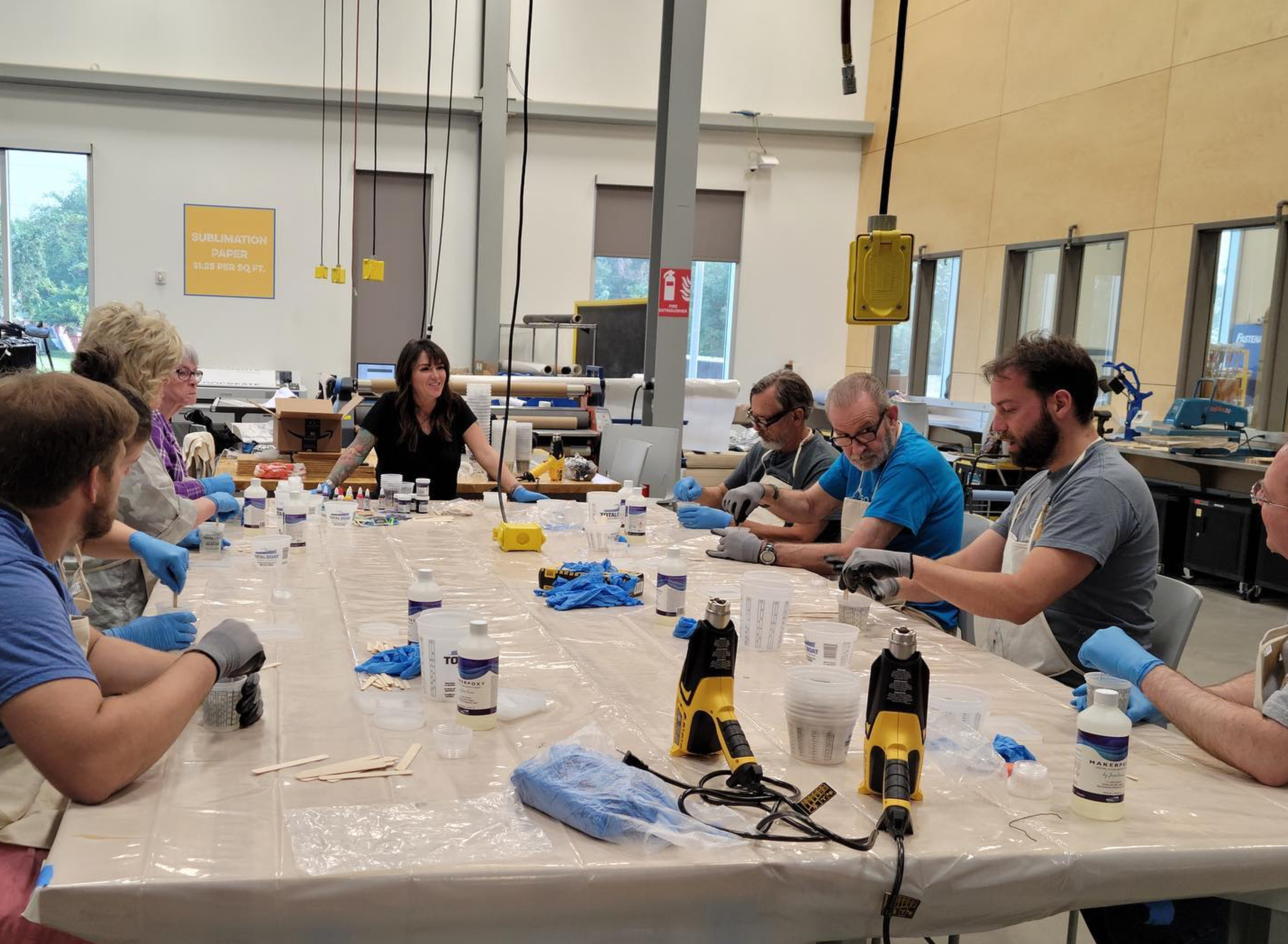 members sitting at a large table in epoxy class working on their project