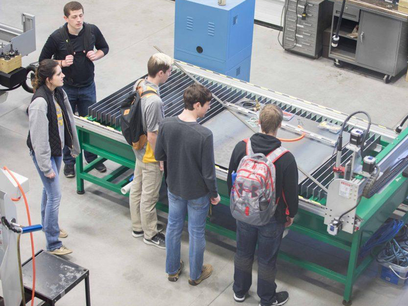 A group of people looking at machinery