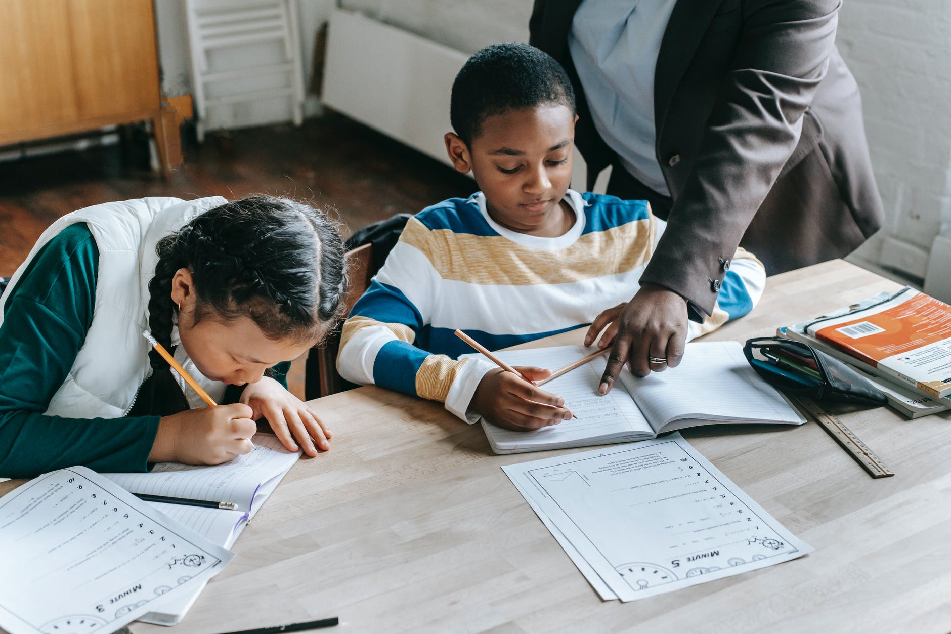 Two refugee children are studying under the teacher's instruction