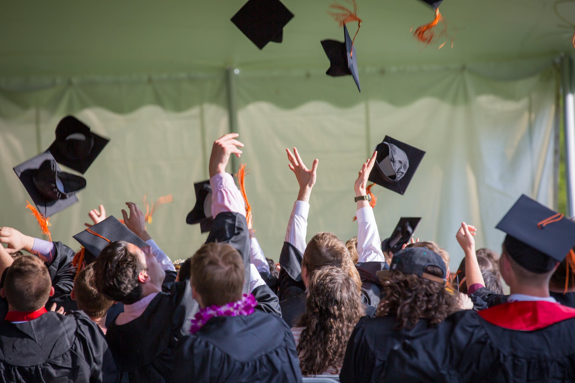 A group of students throwing graduation caps into the air