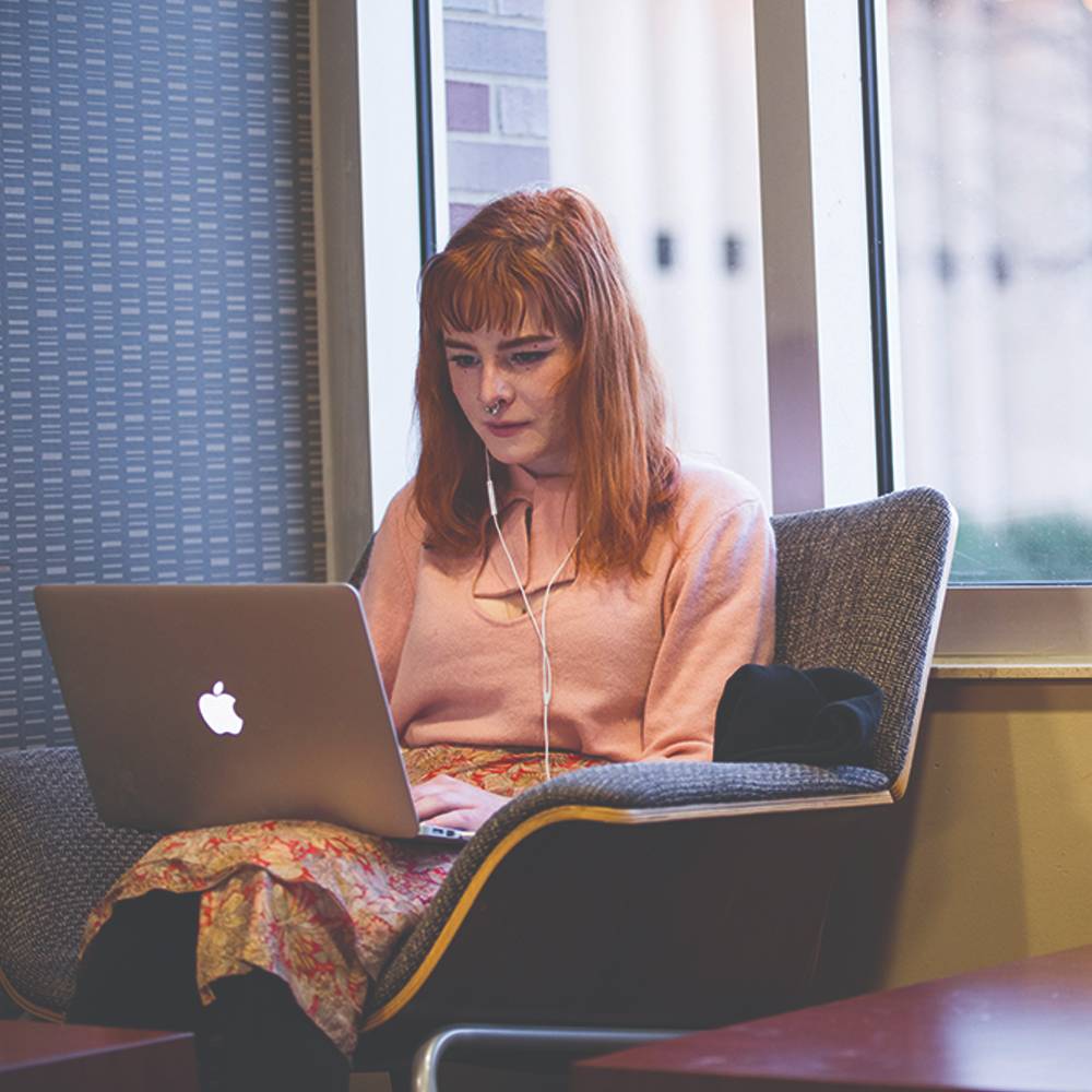 Young woman in chair working on laptop