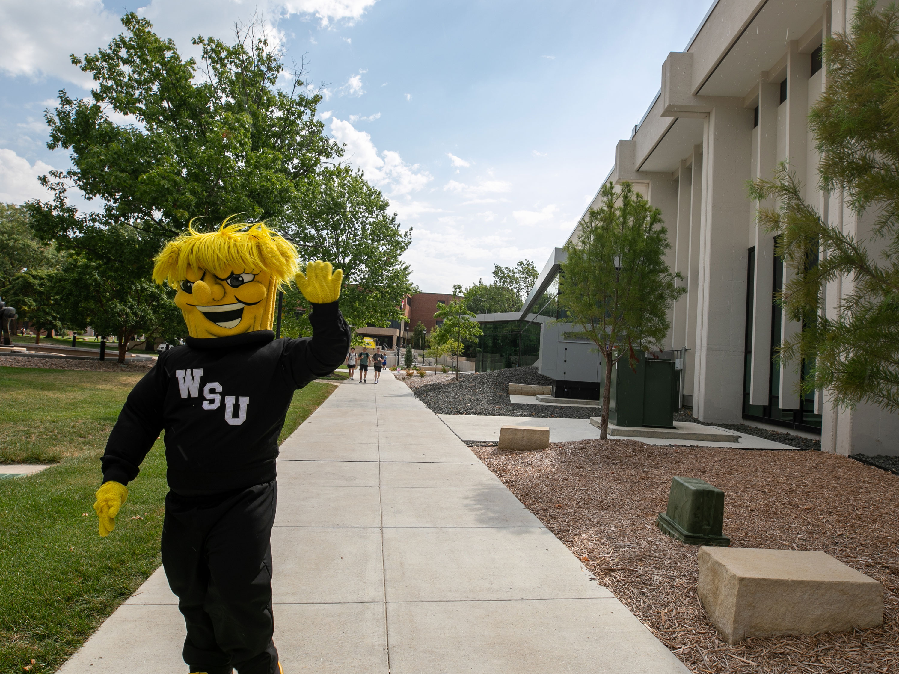 WU waving by the Student Success Center