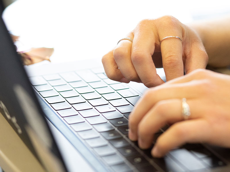 A person's hand on a laptop.