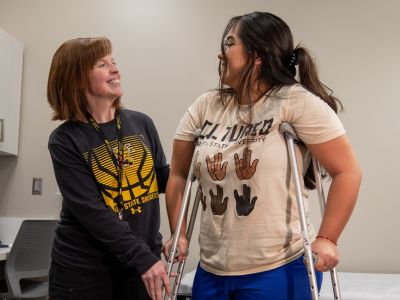 Nurese helping student with crutches