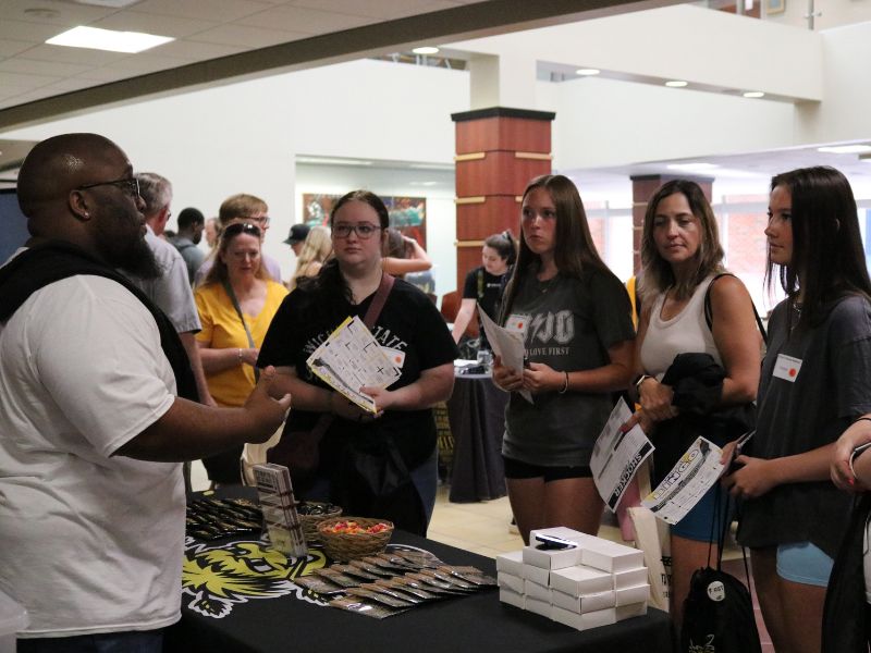 Staff handing out information to students