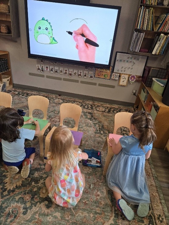 children learing to draw from a screen