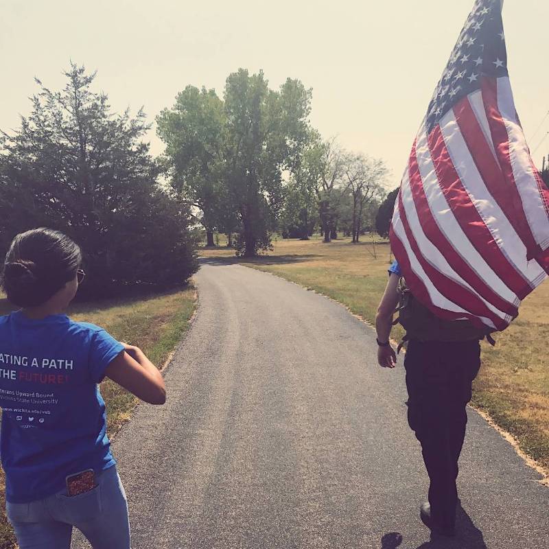 woman and man holding american flag walking