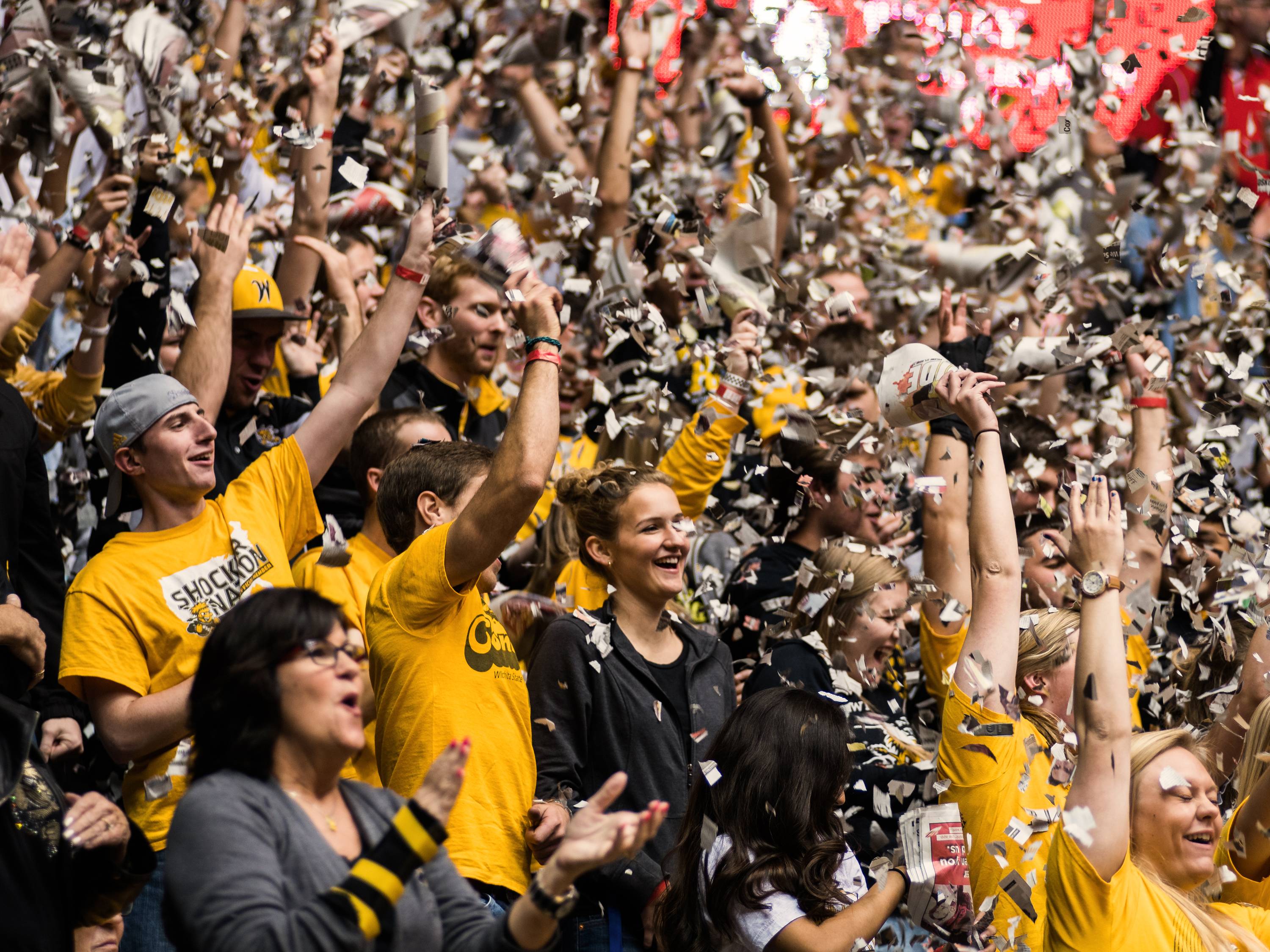 Students celebrate a Shocker basketball win with confetti at Charles Koch Arena