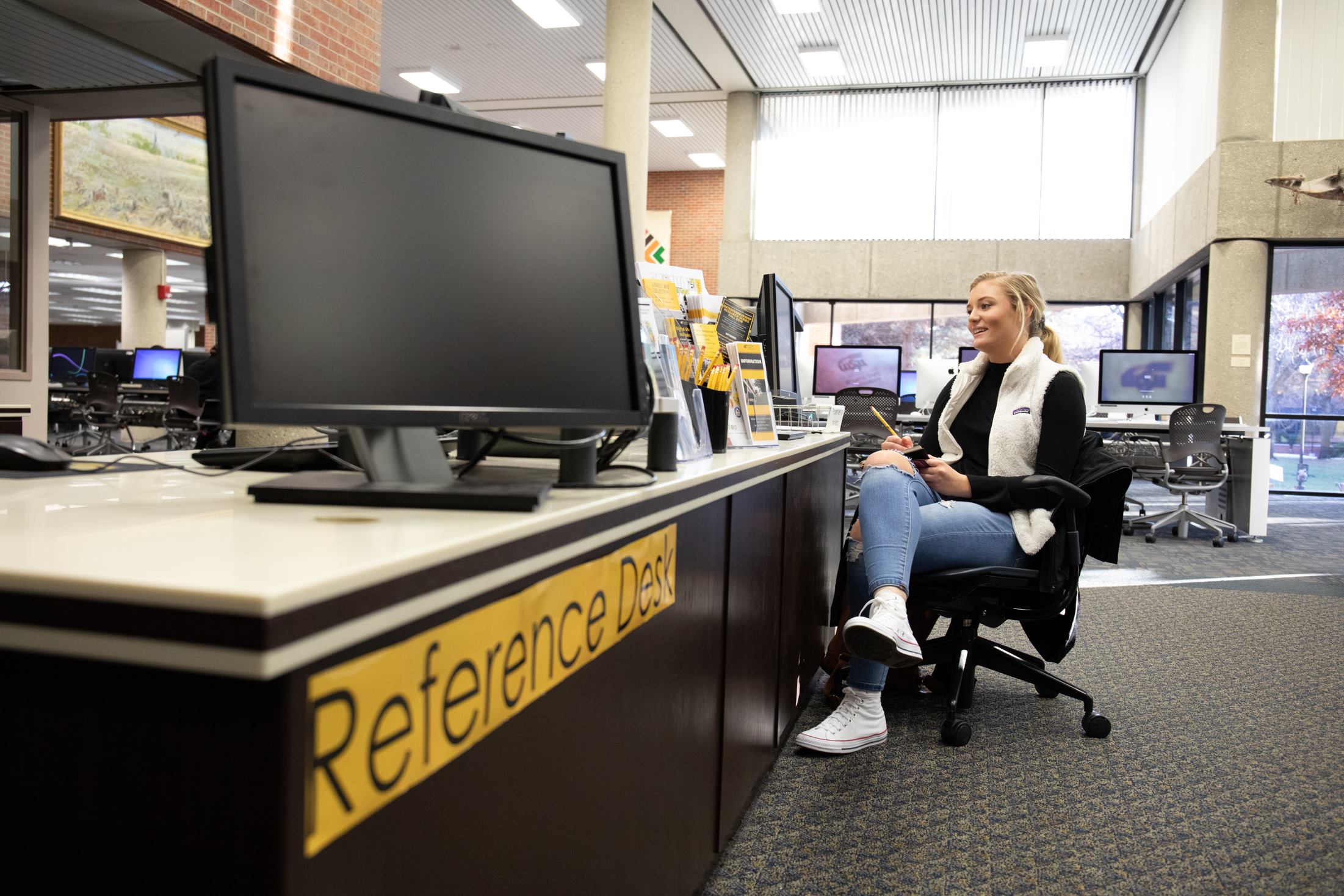 A student at the library Reference Desk