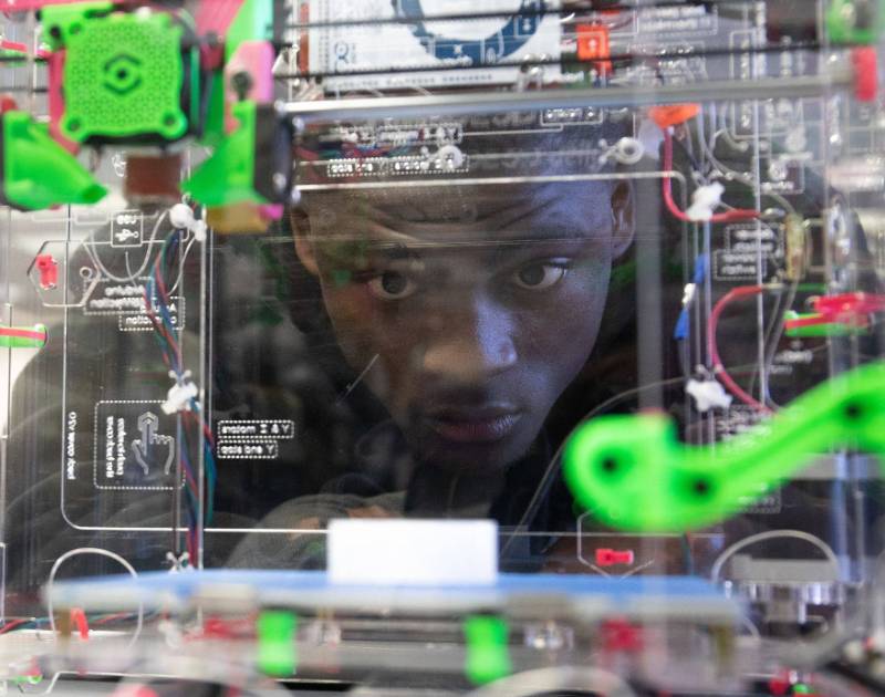 Student watching a 3D printer at work