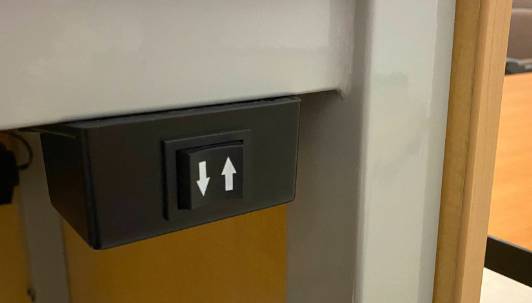 The up and down arrows on the lectern will adjust the height of the lectern to suit the user.