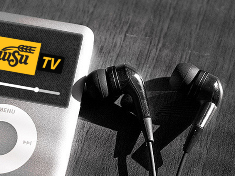 An ipod-style MP3 player with a WSUTV logo on its screen sitting next to a pair of earbuds. 