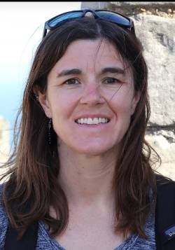 Photo of Dr. Manning with stone and sea behind her