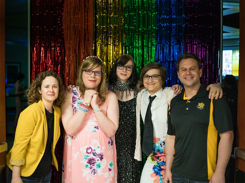 Students and staff individuals taking a picture together at Pride Prom.