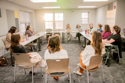 A group of young professionals sit in circle talking about mentorship
