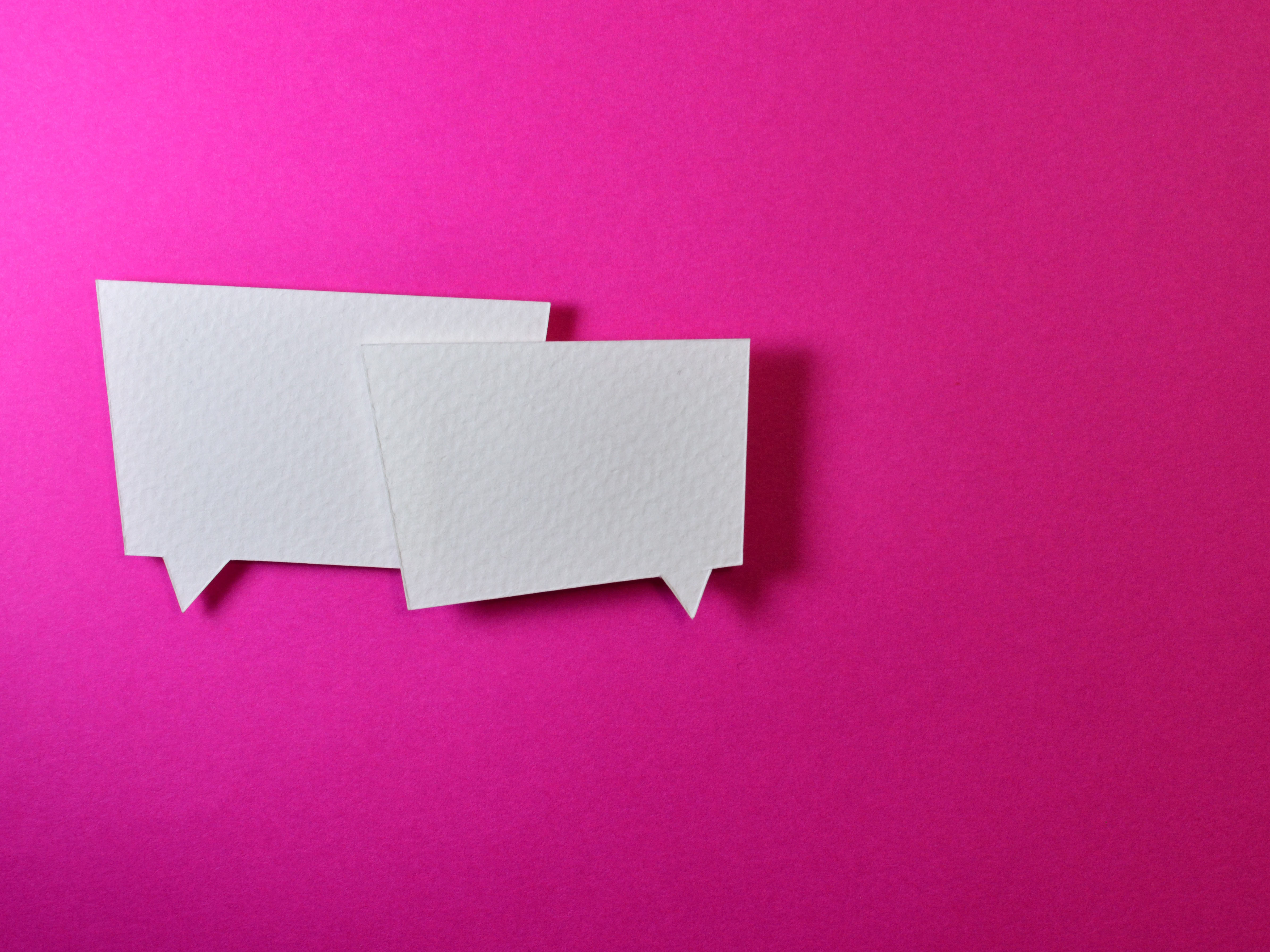 white conversation bubbles on pink background
