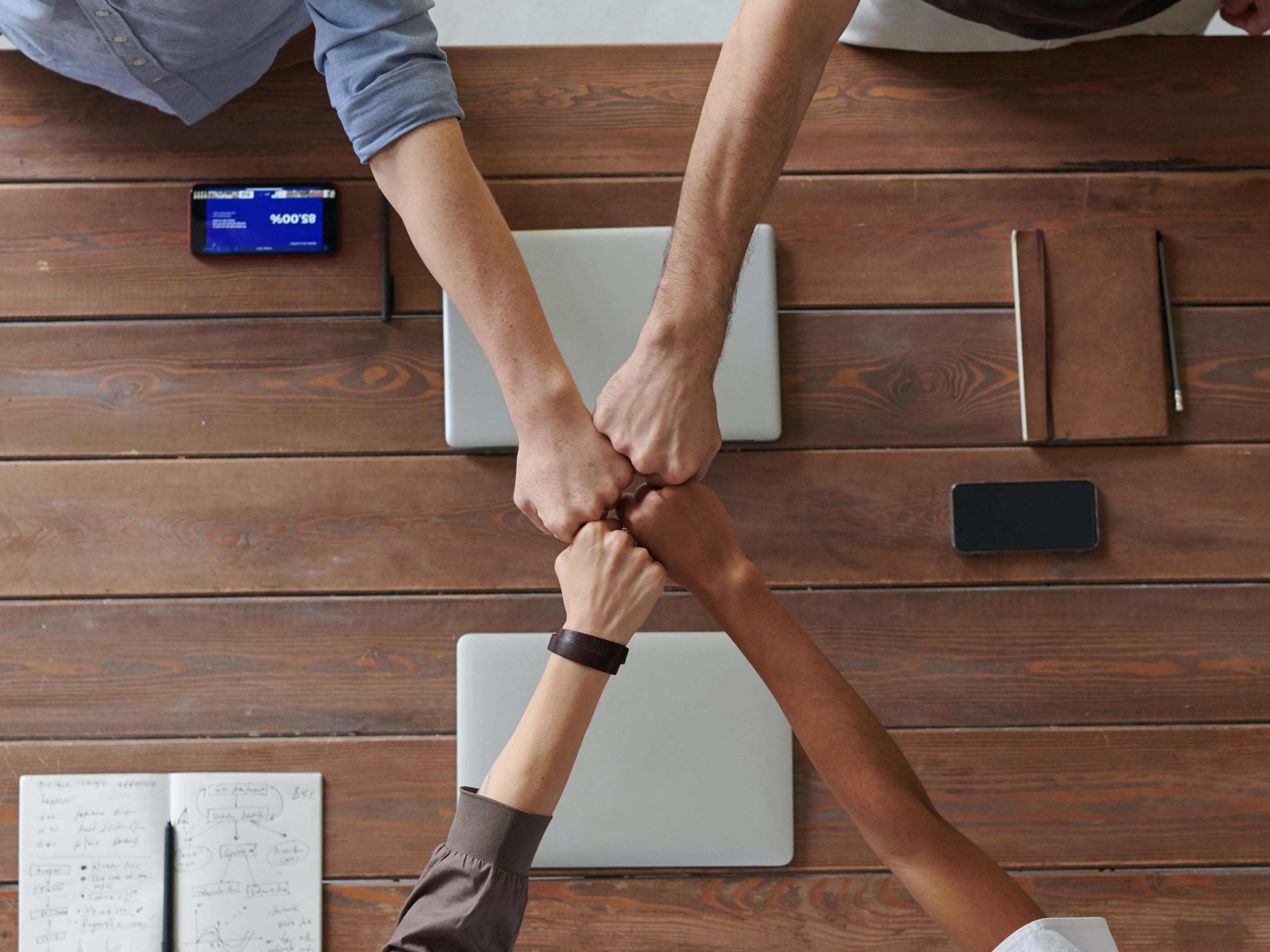 four team members fist bumping