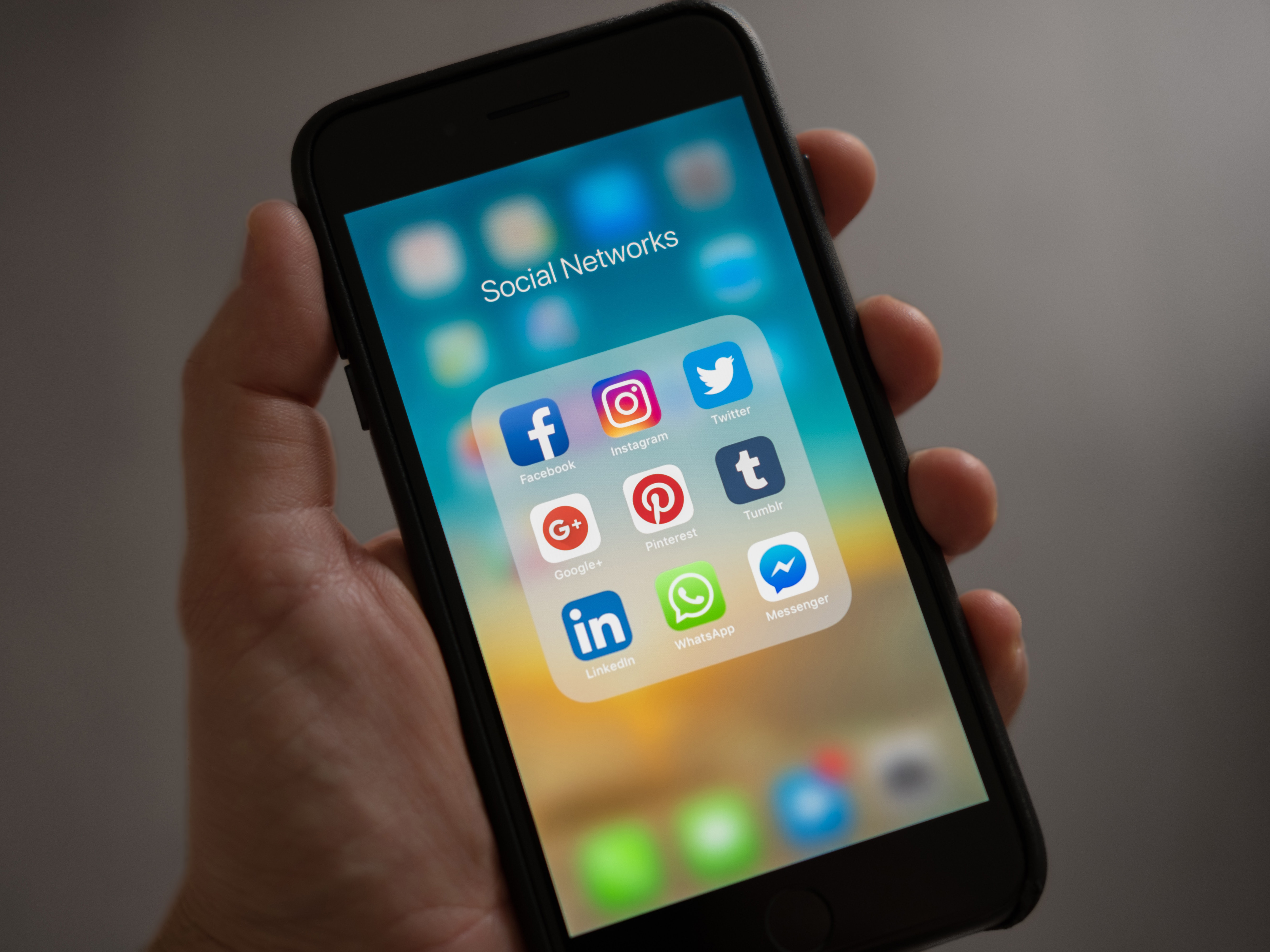 person holding phone showing social media apps