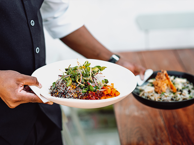 Chef holding two food dishes.